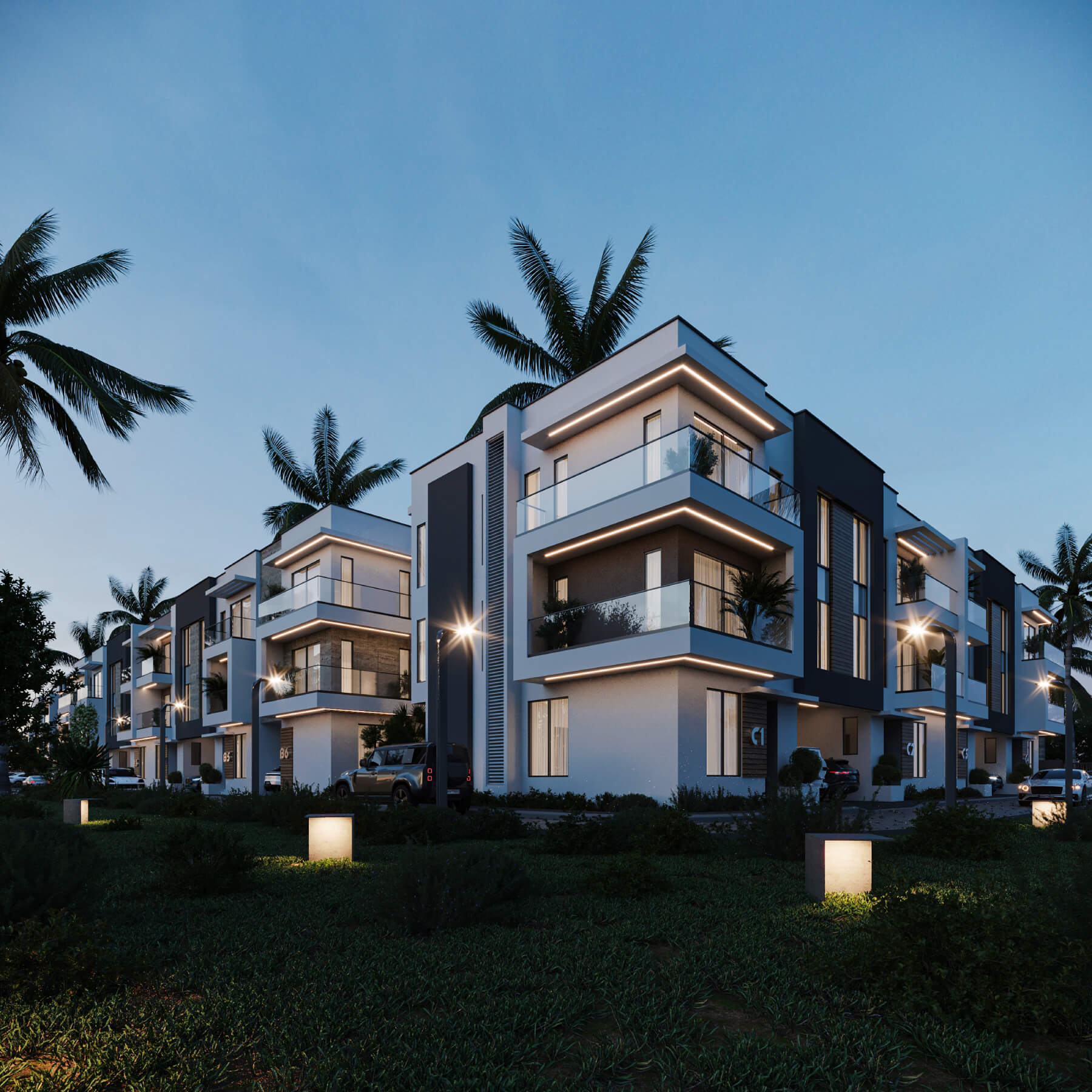 Blissville Terraces at dusk, with warm lighting along private balconies and palms